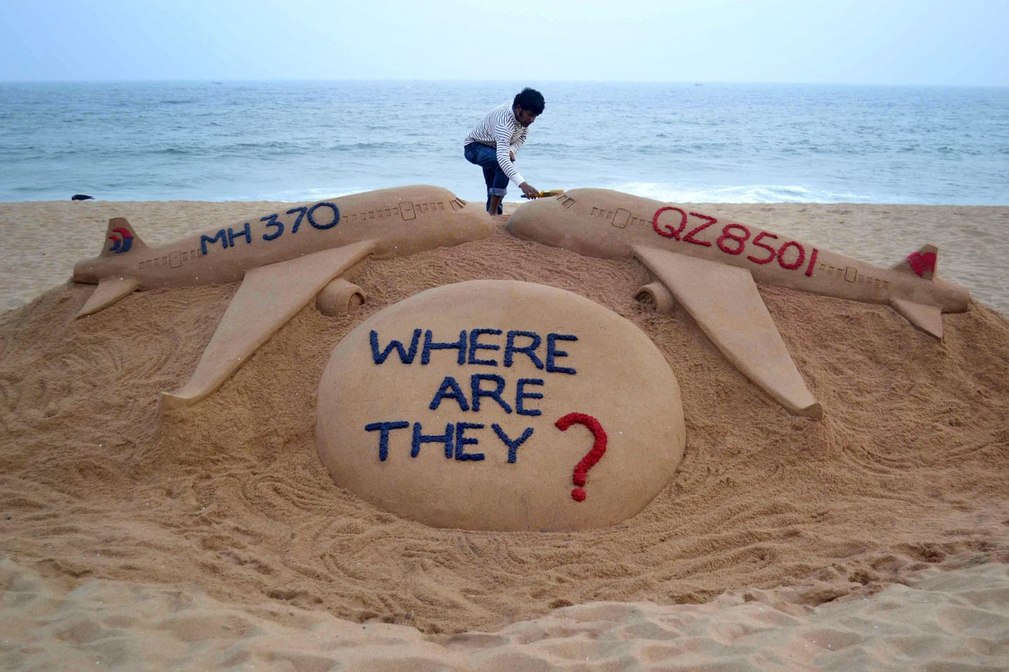 India kunstnik Sudarsan Pattnaik kahele kadunud lennule pühendatud liivaskulptuurile viimast lihvi andmas.
