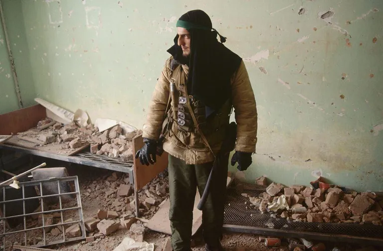 Чеченский боец в разрушенном доме в центре Грозного.