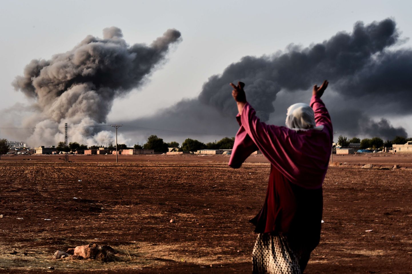 Süüria piiri taga Türgis toimuvat jälgiv naine reageerib Kobanes islamistide vastu toime pandud õhurünnakule.