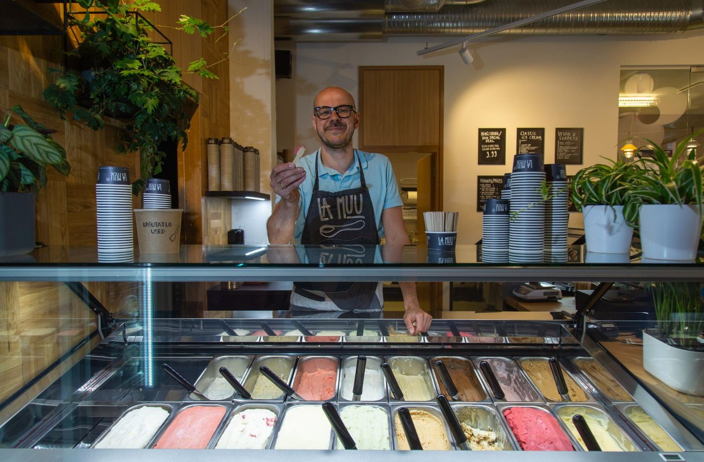 La Muu tegevjuht Rasmus Rask oma jäätisekohviku leti taga. Maitsmiseks mõeldud pulgakesel on spetsiaalselt kohviku jaoks valminud maasika-balsamico jäätis.