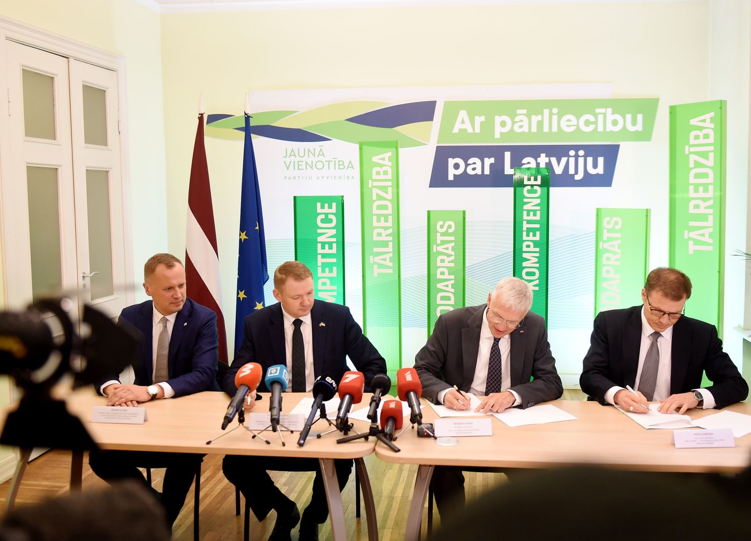 Edgars Tavars (AS) (no kreisās), Edvards Smiltēns (AS), Krišjānis Kariņš (JV) un Raivis Dzintars (NA) paraksta memorandu par sadarbību 14. Saeimā.