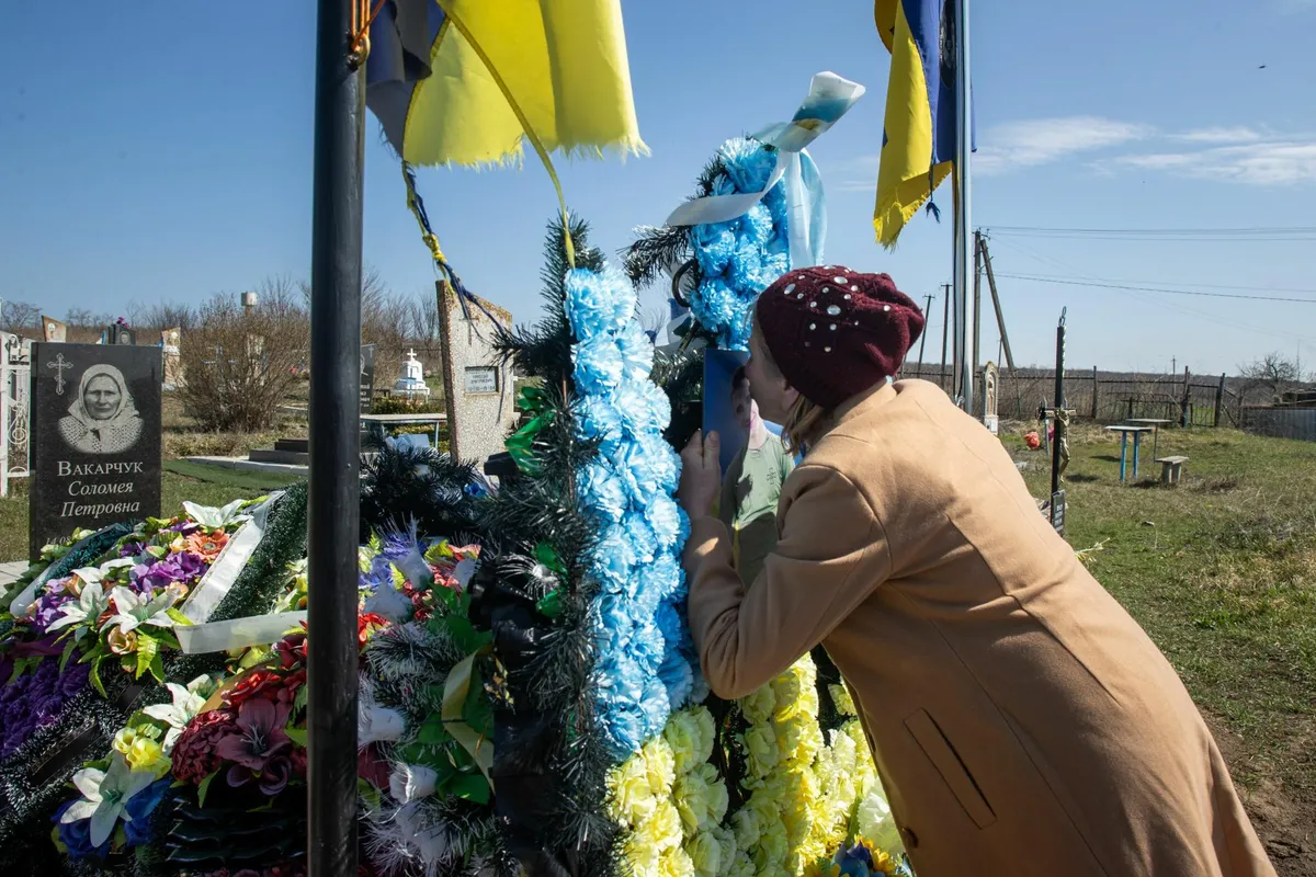 Светлана Олинык у могилы своего 22-летнего сына Андрея. Могила до сих пор утопает в цветах. По словам матери, сюда часто приходят друзья сына и его сослуживцы-морпехи.
