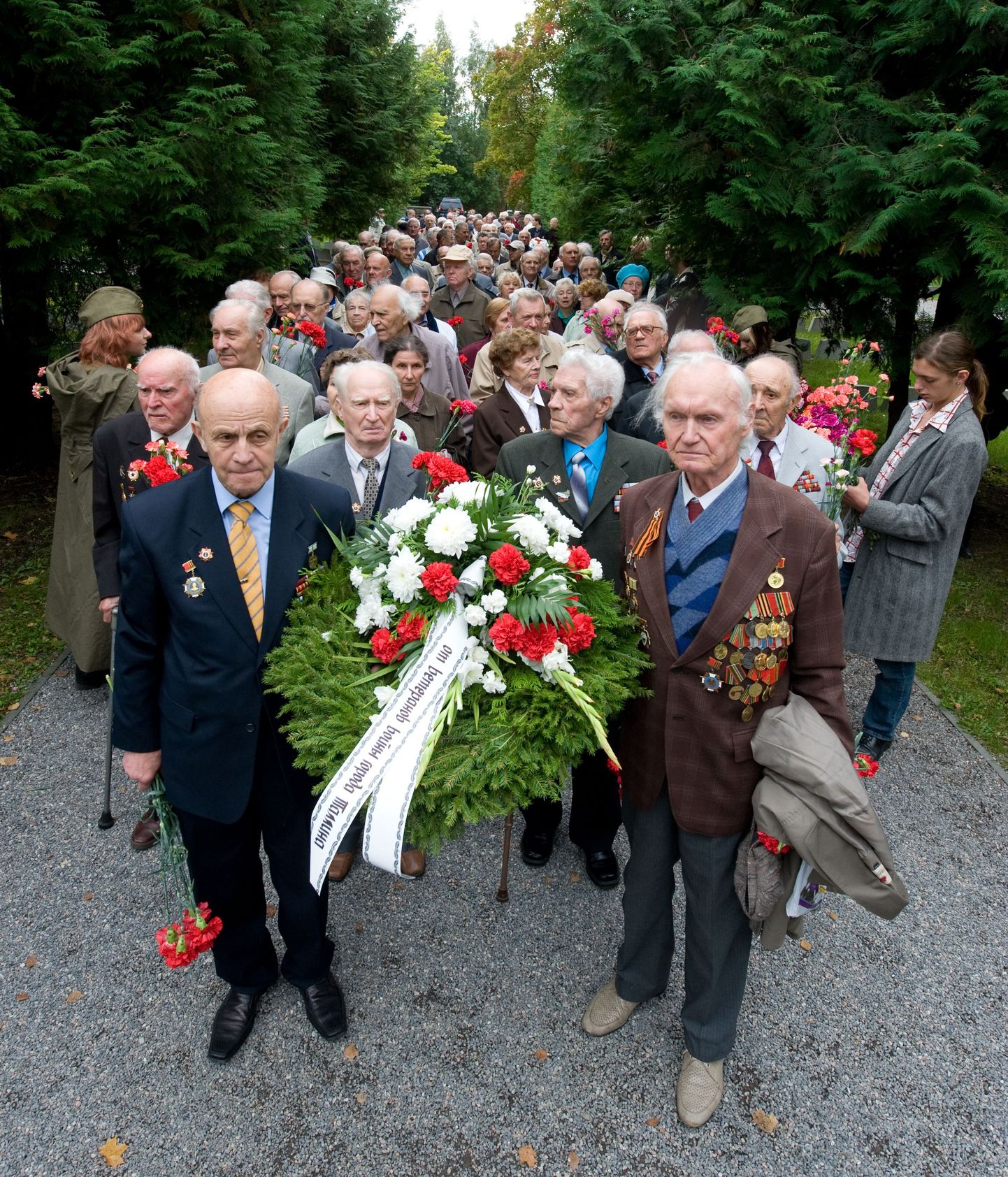 У памятника павшим на Военном кладбище Таллинна. Цветы возлагают ветераны войны.