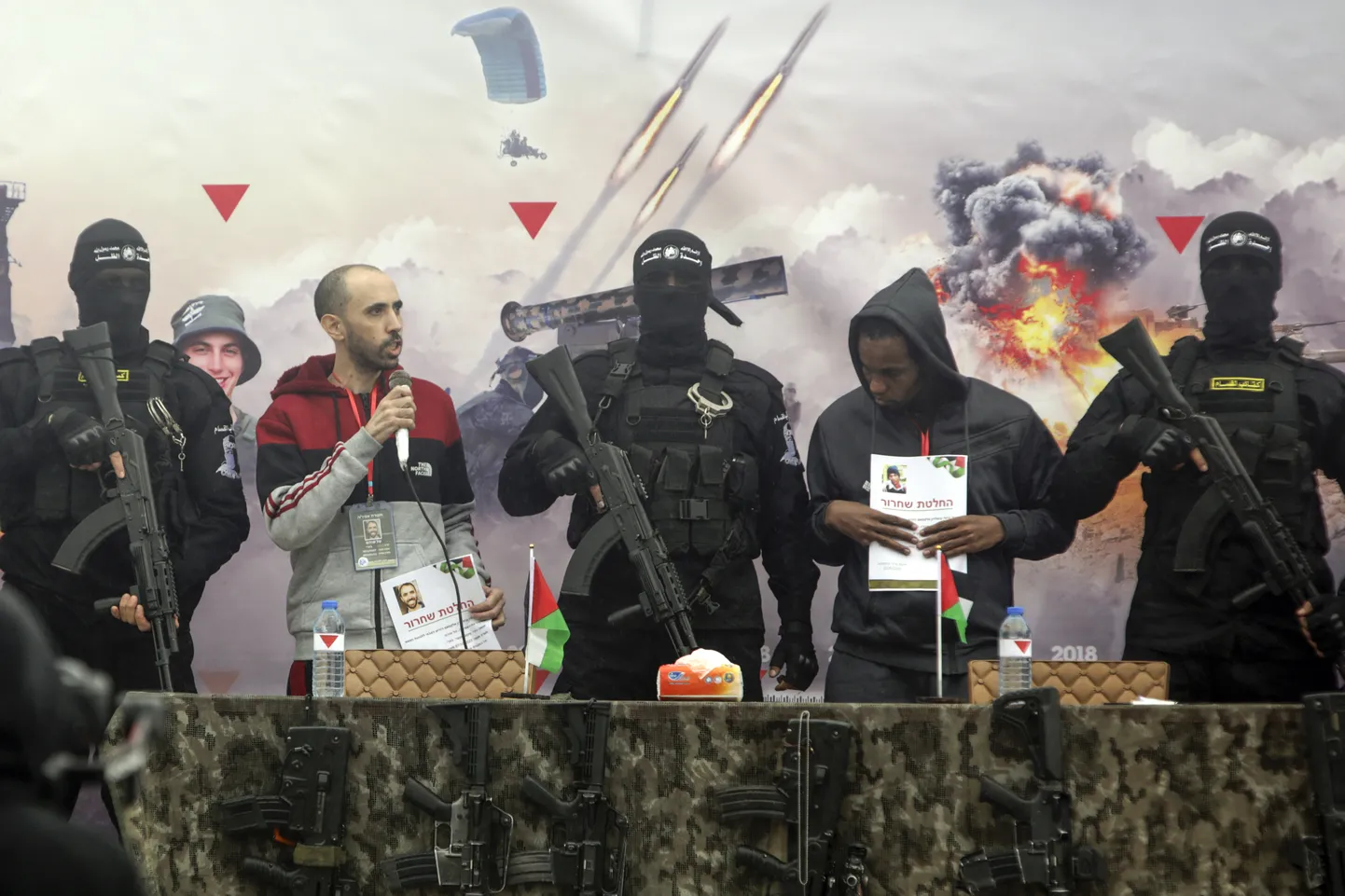 Iisraeli pantvangid Tal Shoham (paremal) ja Avera Mengisto (vasakul) ümbritsetuna Hamasi võitlejatest. 22. veebruar 2025.