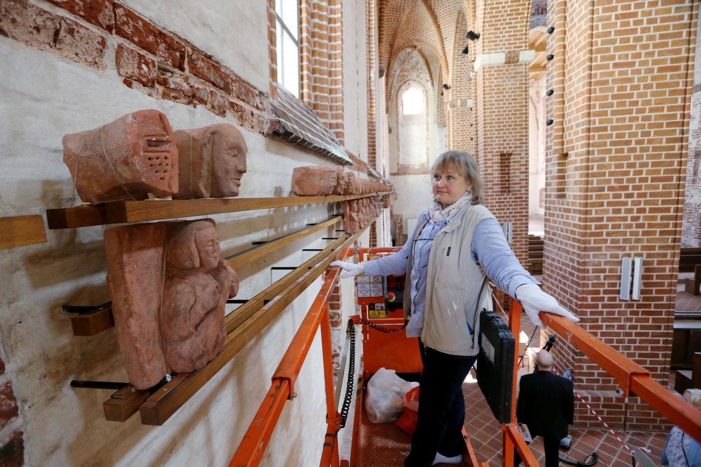Kunstiteadlane, konservaator Eve Alttoa kinnitas reedel Jaani kirikus riiulile skulptuurseid päid ja poolfiguure tõstuki abil. Riiulil on teiste hulgas rüütli pea (ülal vasakul).