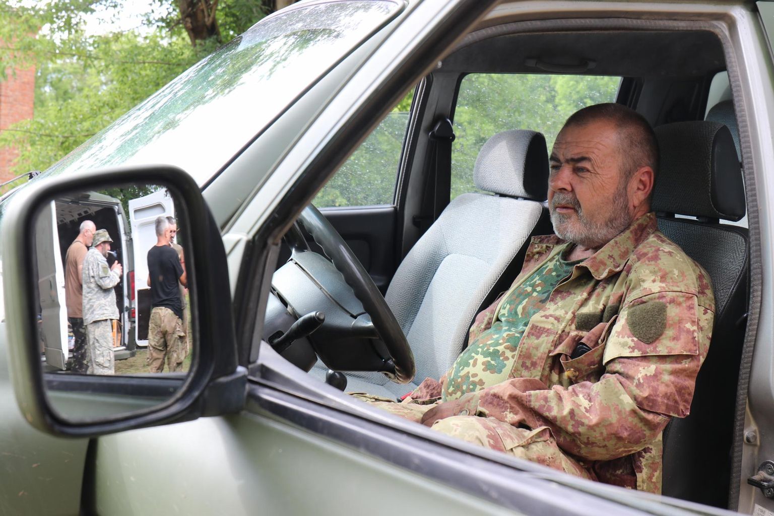The soldier of the OUN battalion, called Malõš (Little Man), is sitting in one of several jeeps, which were provided to the battalion by Estonian volunteers from the NGO Paris Moto. Malõš is known in the battalion for the fact that he has been fighting with his Labrador dog for the last four years. The mirror shows other OUN fighters at the battalion base.