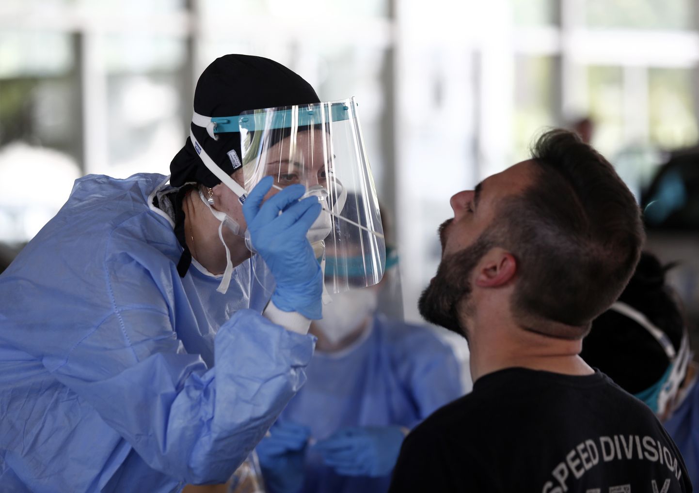 В Греции медработник проверяет туриста на коронавирус.