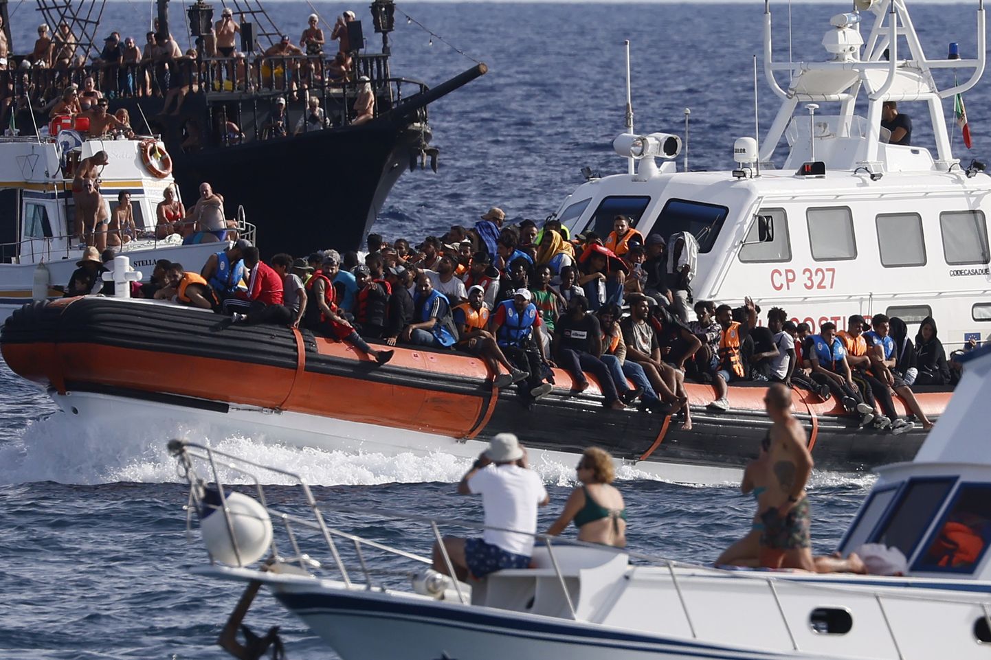 Itaalia rannavalve paat vedamas Lõuna-Itaalias Sitsiilias asuva Lampedusa saare sadama lähedal migrante.