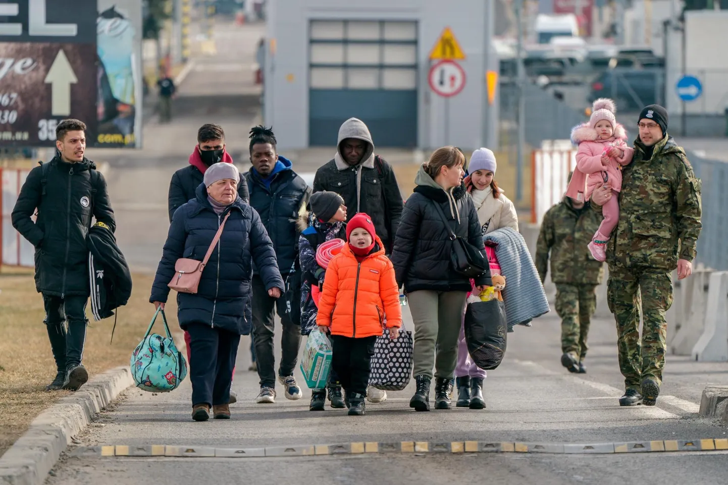 Poola sõdurid aitamas Ukrainast saabuvatel pagulastel ületada Ukraina-Poola piiri. 