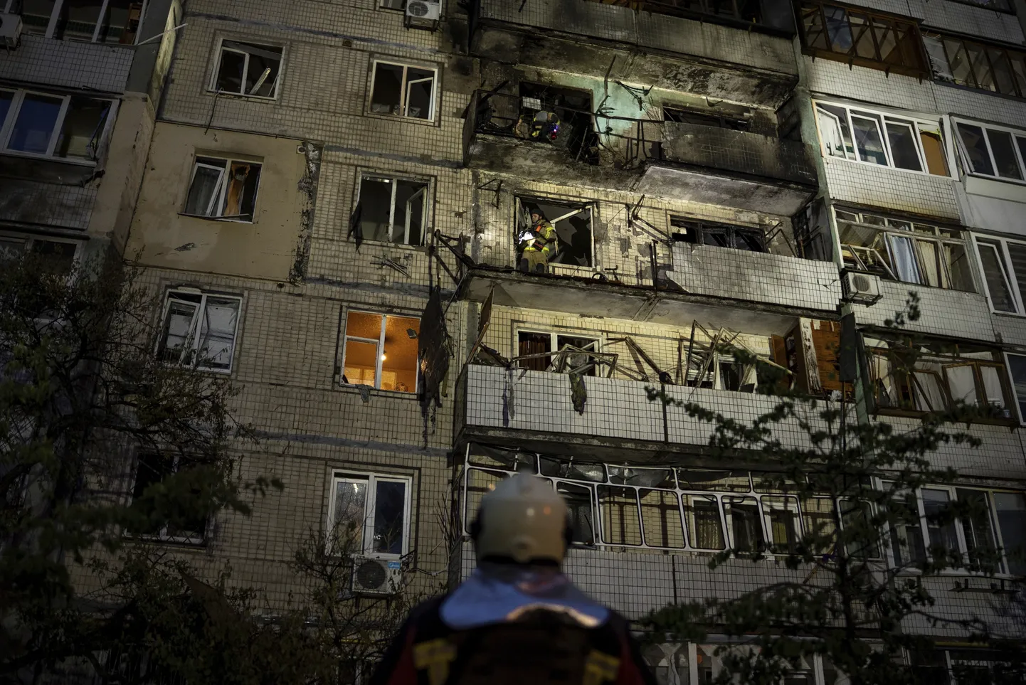 Glābējs vada savus kolēģus notikuma vietā pie dzīvojamās ēkas, kas cietusi Krievijas uzbrukuma rezultātā, Kijivā, Ukrainā, sestdien, 2025. gada 24. maijā.