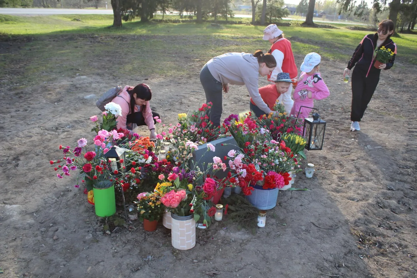 Leena (keskel halli jakiga) ja Katja (vasakul roosas) lastega Tapa vennashaua monumendi endisele asukohale 9. mail lilli toomas.