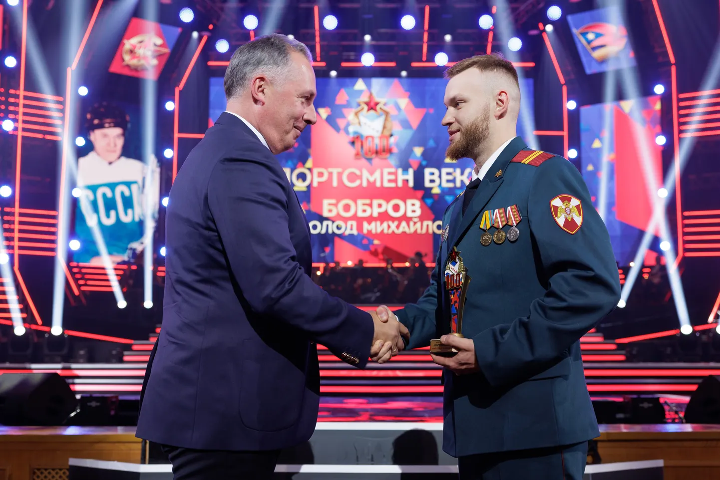 Venemaa olümpiakomitee president Stanislav Pozdnjakov (vasakul) ulatab äsja rindelt tulnud Vsevolod Bobrov juuniorile vanaisale mõeldud autasu