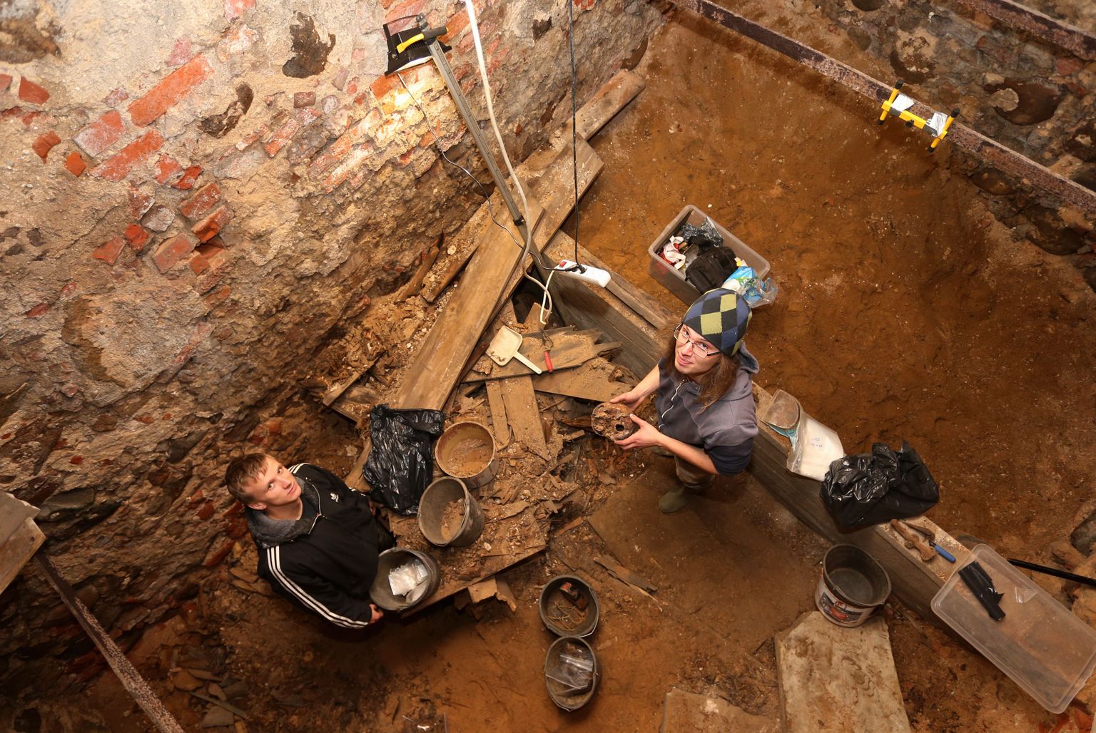 Tartu ülikooli arheoloogidel Jaak Veskel (vasakul) ja Martin Malvel jagub hauakambris tööd selle nädala lõpuni. Malve peab hea seisma selle eest, et kõik sinivereliste luud saaks nagu kord ja kohus kokku  kogutud.