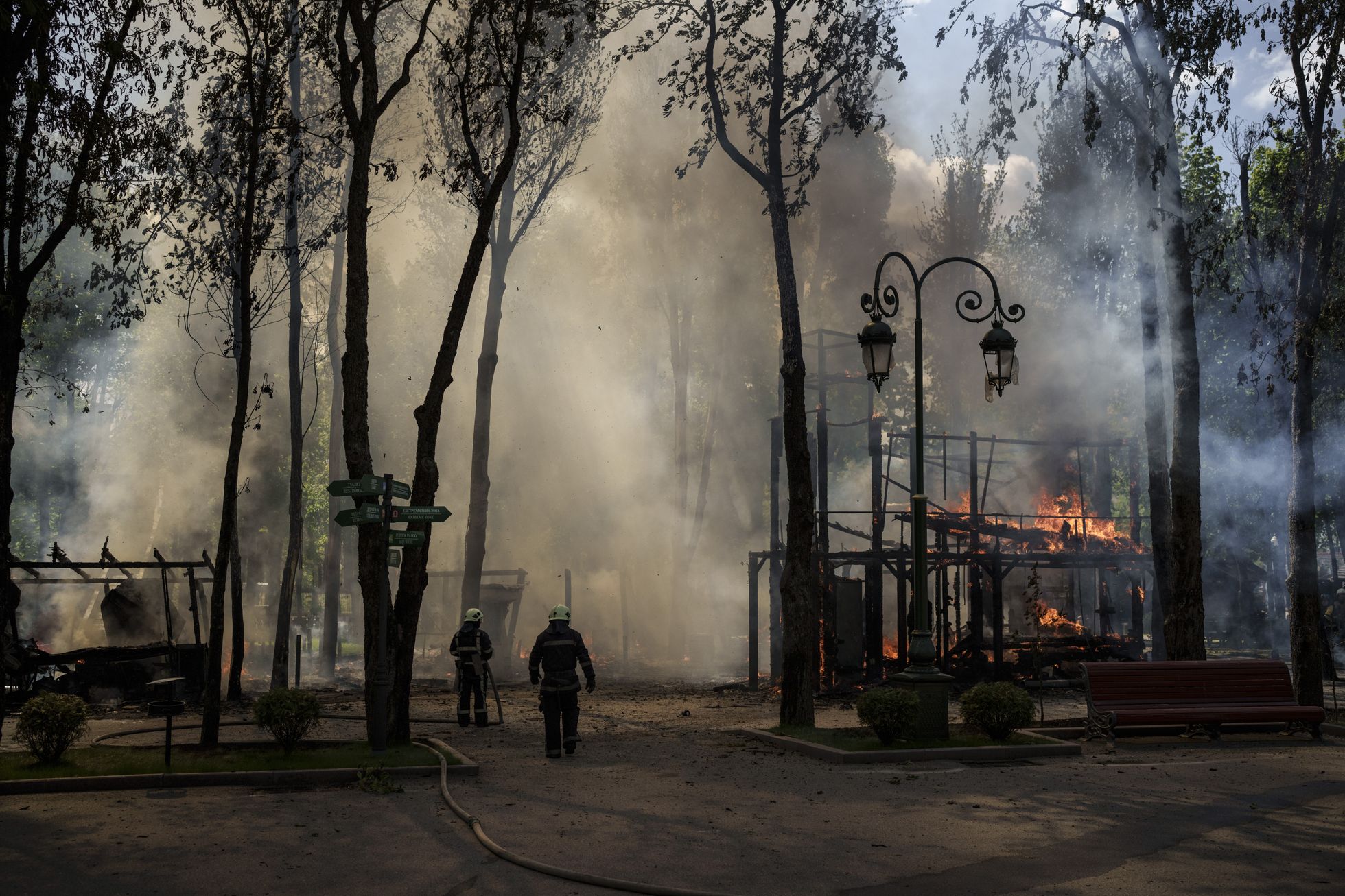 Tuletõrjujad kustutavad Vene rünnaku järel puhkenud põlengut ühes Harkivi pargis.