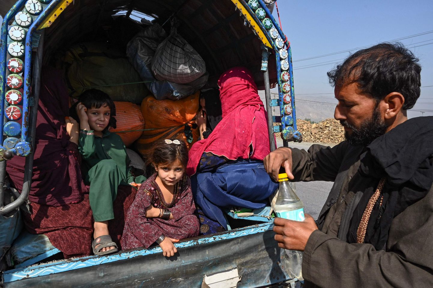 Семья афганцев примерно в 30 км к западу от Пешавара (Пакистан), когда они возвращаются в Афганистан после решения правительства Пакистана выдворить людей, незаконно находящихся в стране. 6 октября 2023 года.