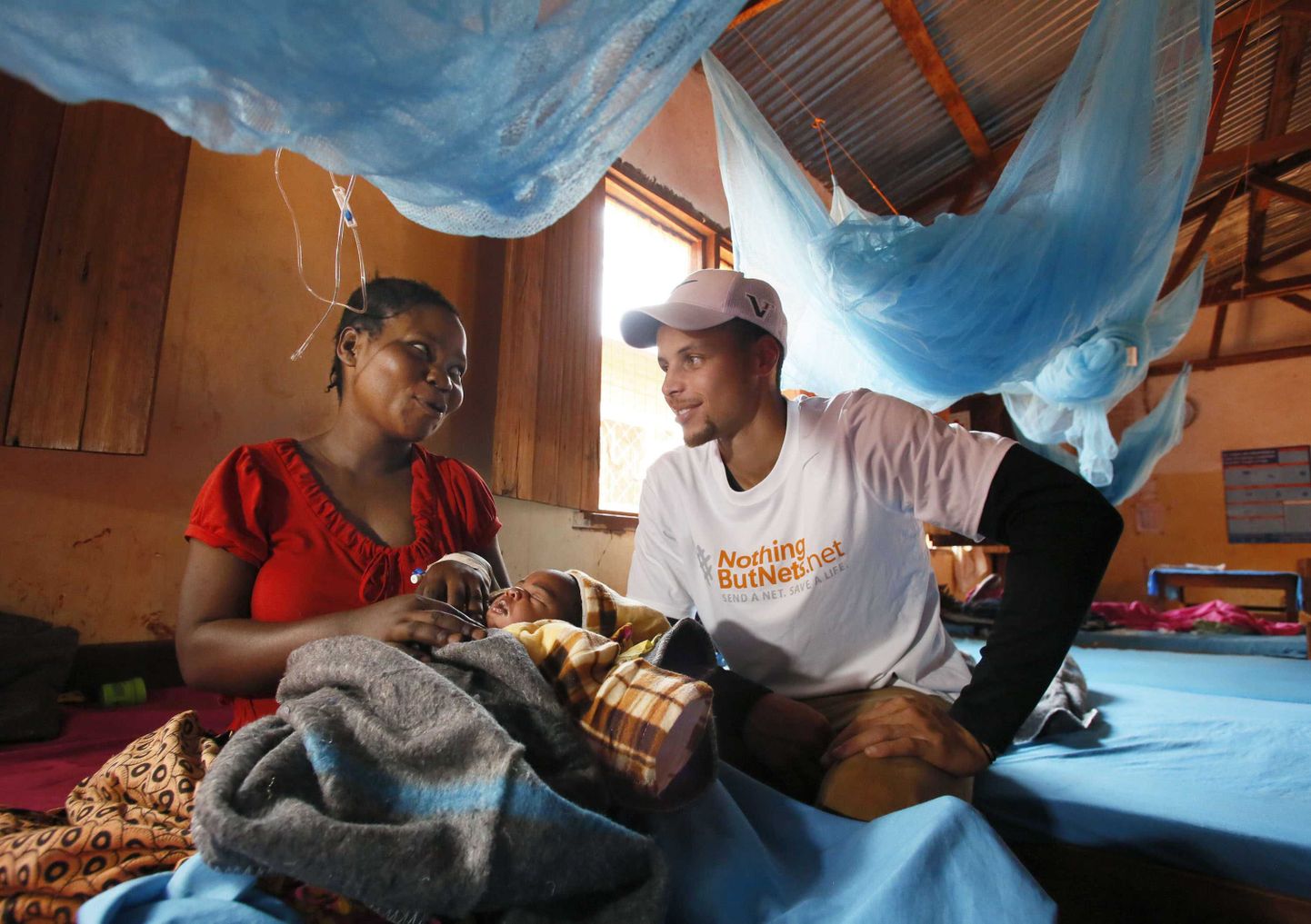NBA korvpalliliiga superstaar Stephen Curry käis tänavu juulis külas Tansaanias Nyarugusu pagulaslaagris malaariavõrke jagamas. Pildil räägib ta malaariast paraneva naisega.