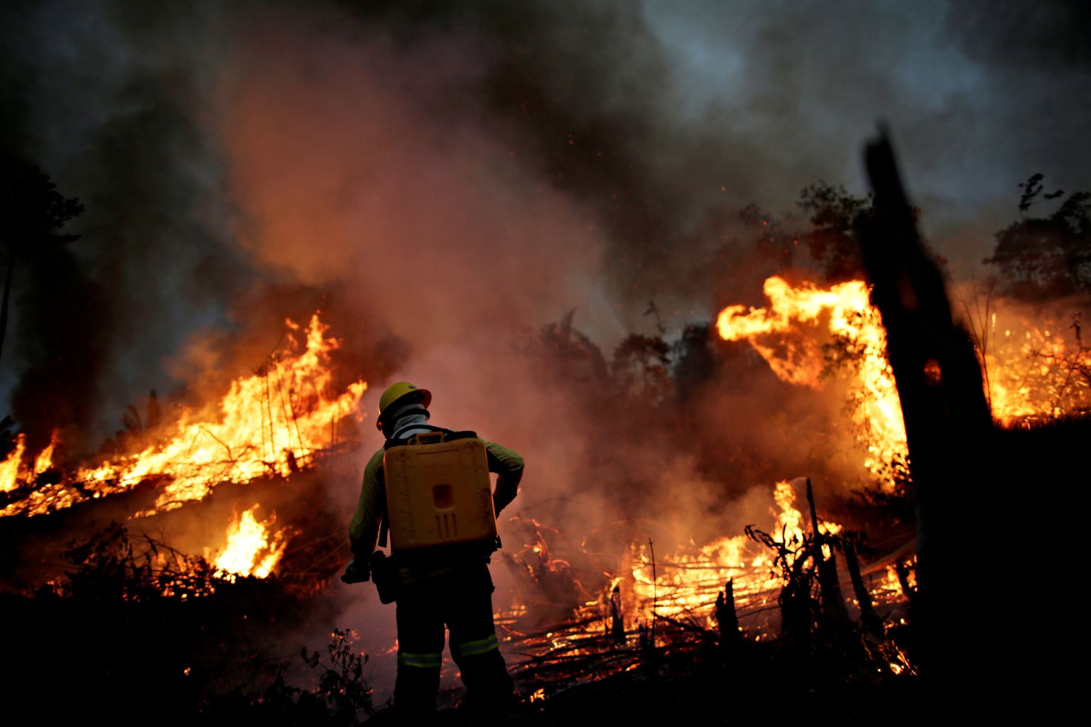 FILE PHOTO: A Brazilian Institute for the Environment and Renewable Natural Resources (IBAMA) fire brigade member attempts to control a fire in a tract of the Amazon jungle in Apui, Amazonas State, Brazil, August 11, 2020. Picture taken August 11, 2020. REUTERS/Ueslei Marcelino/File Photo