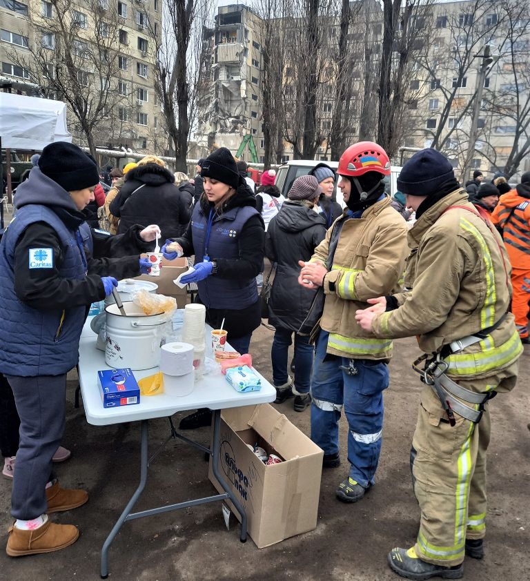 Caritase vabtahtlikud toetamas päästjaid sooja toiduga.