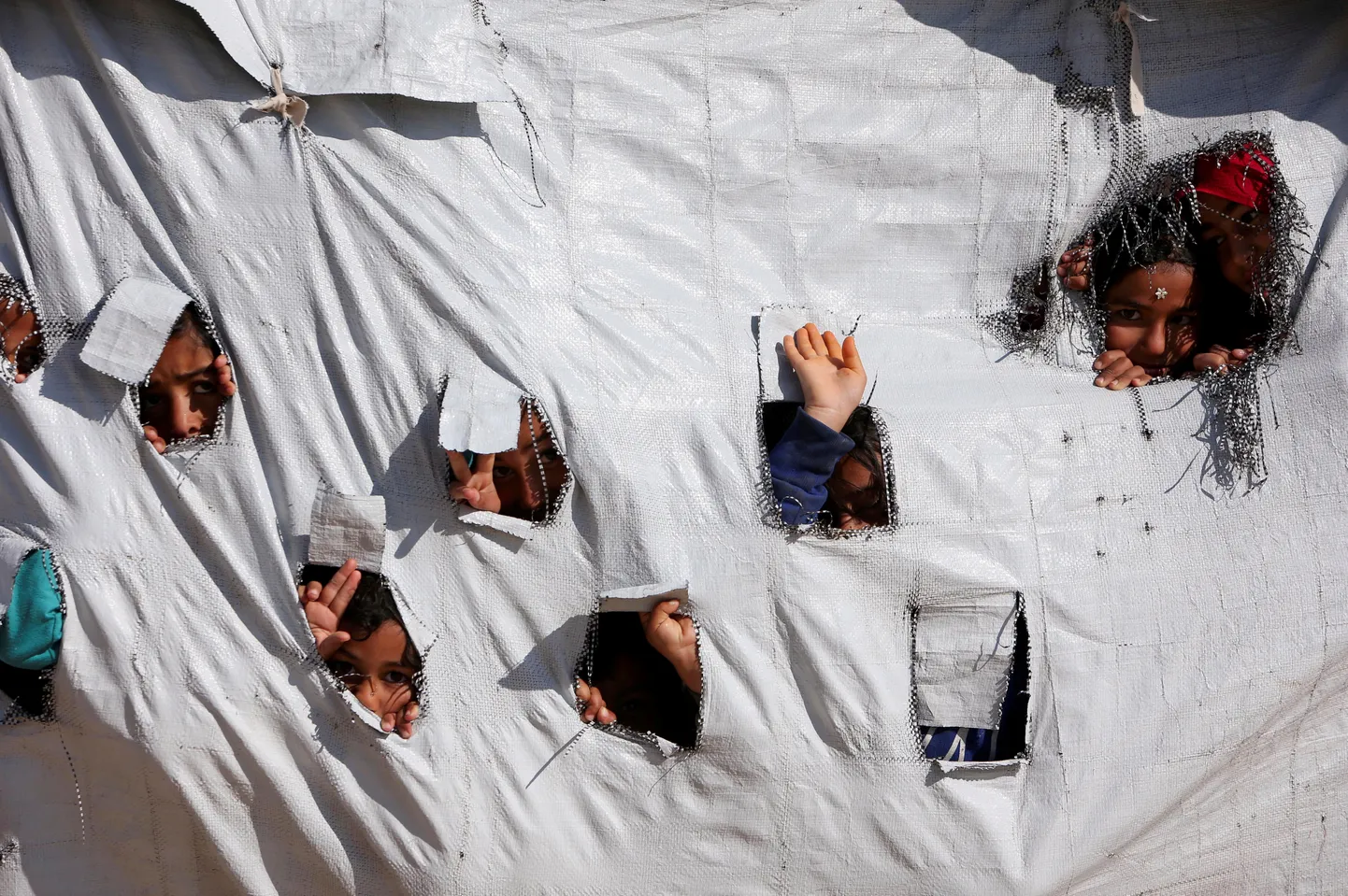 Lapsed vaatavad läbi telgi aukude al-Hol  laagris.