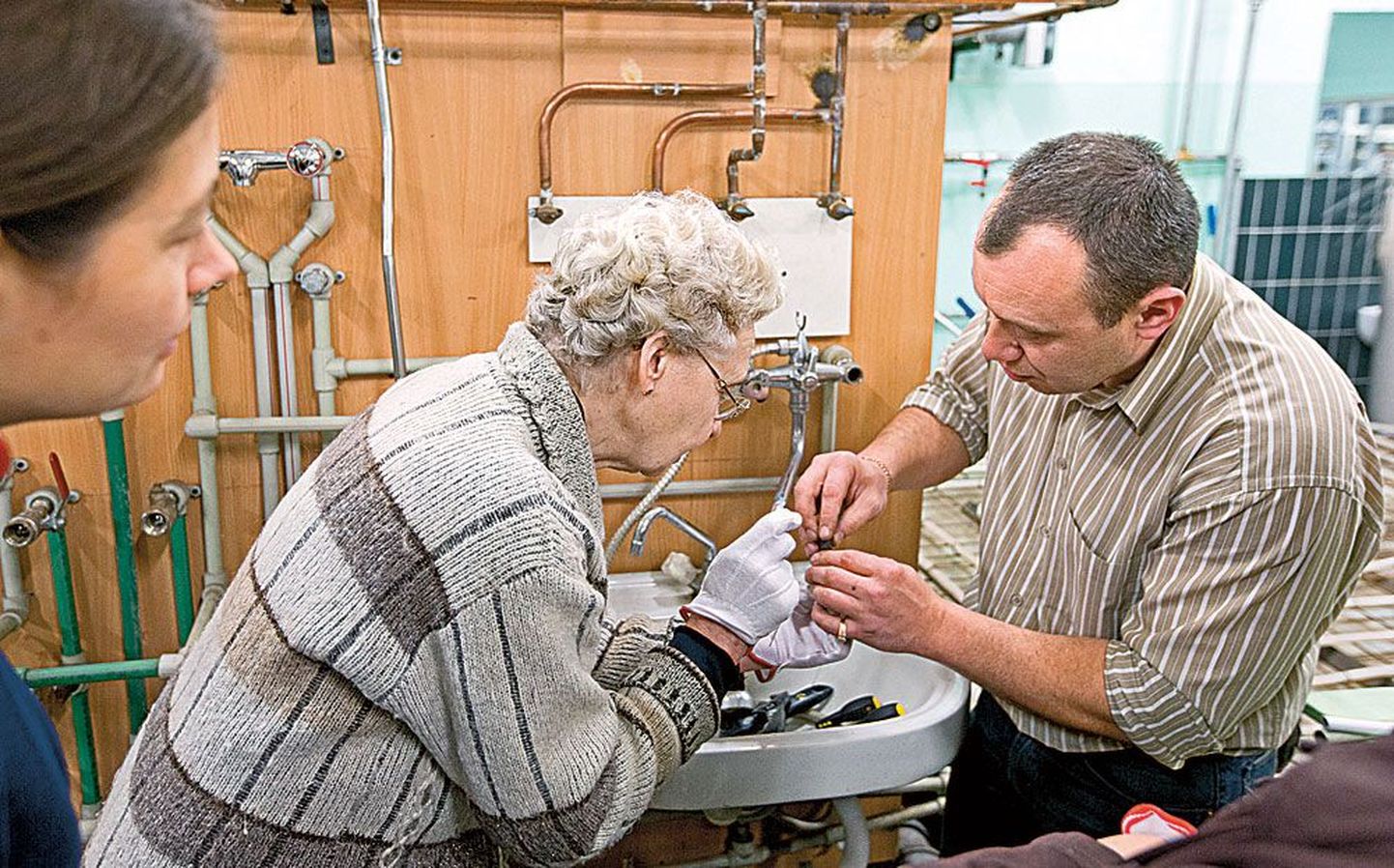 Professionaalne santehnik Roman Issakov (paremal) tutvustamas kursuslasele kraanitihendeid.