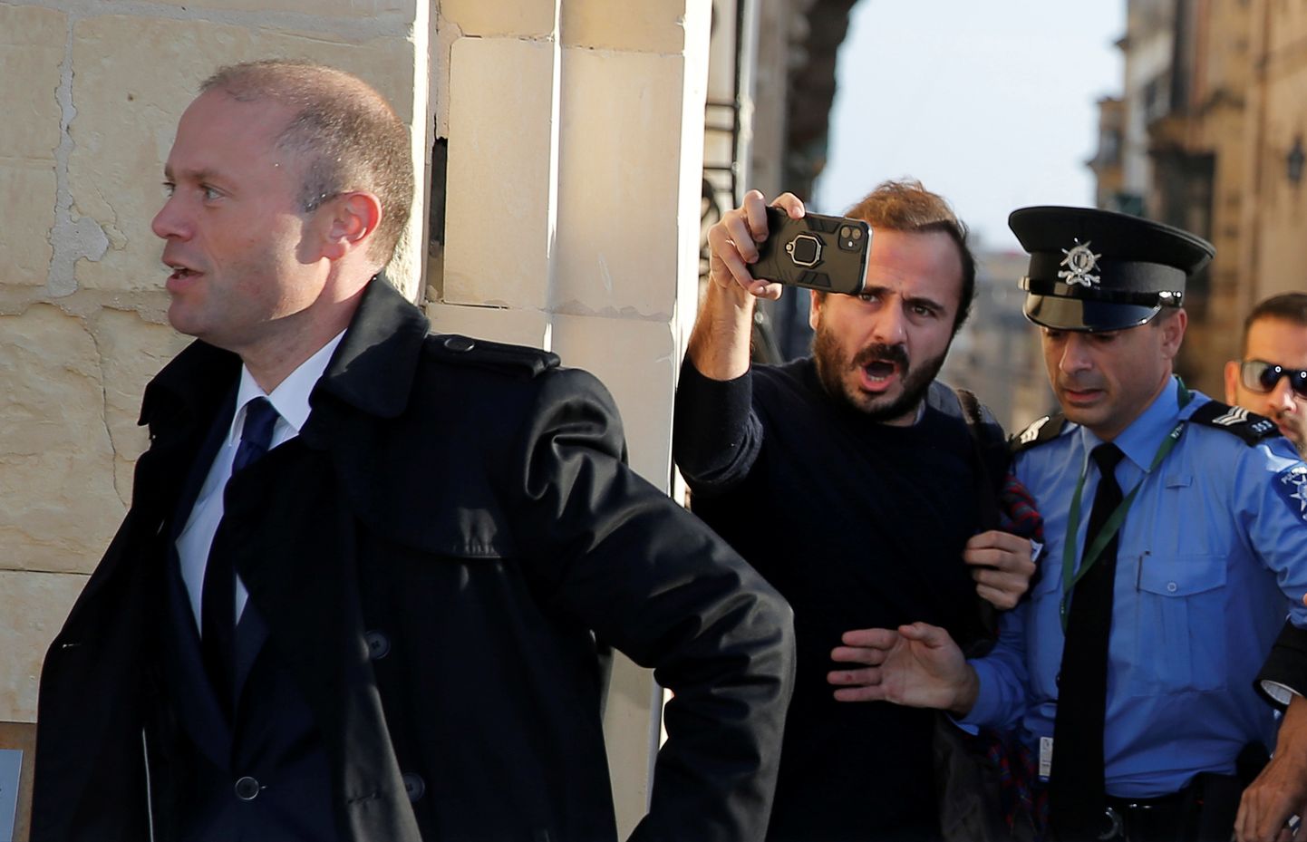 Malta peaminister Joseph Muscat politsei saatel kohtumisele suundumas.