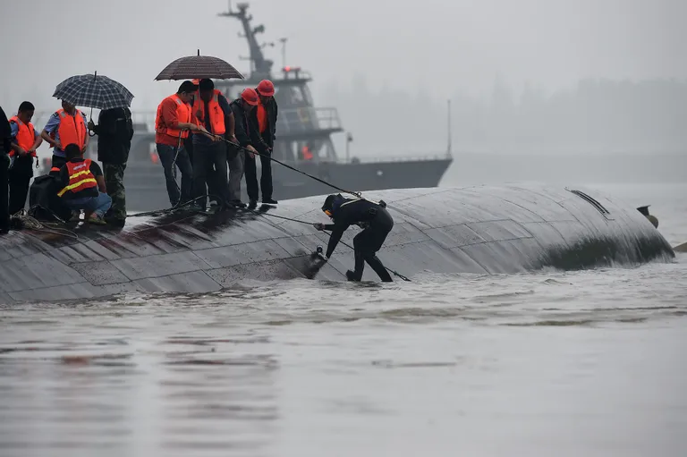 Päästetöötajad  koputavad laevakerel, et saada kontakti lõksujäänud reisijatega.                  Foto: Scanpix