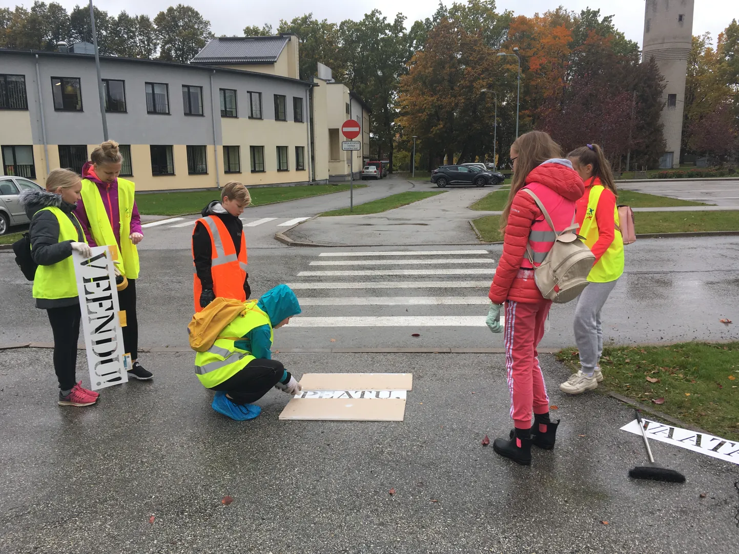 Türi põhikooli õpilased värvivad ülekäiguraja juurde hoiatavaid kirju «Peatu! Vaata! Veendu!».