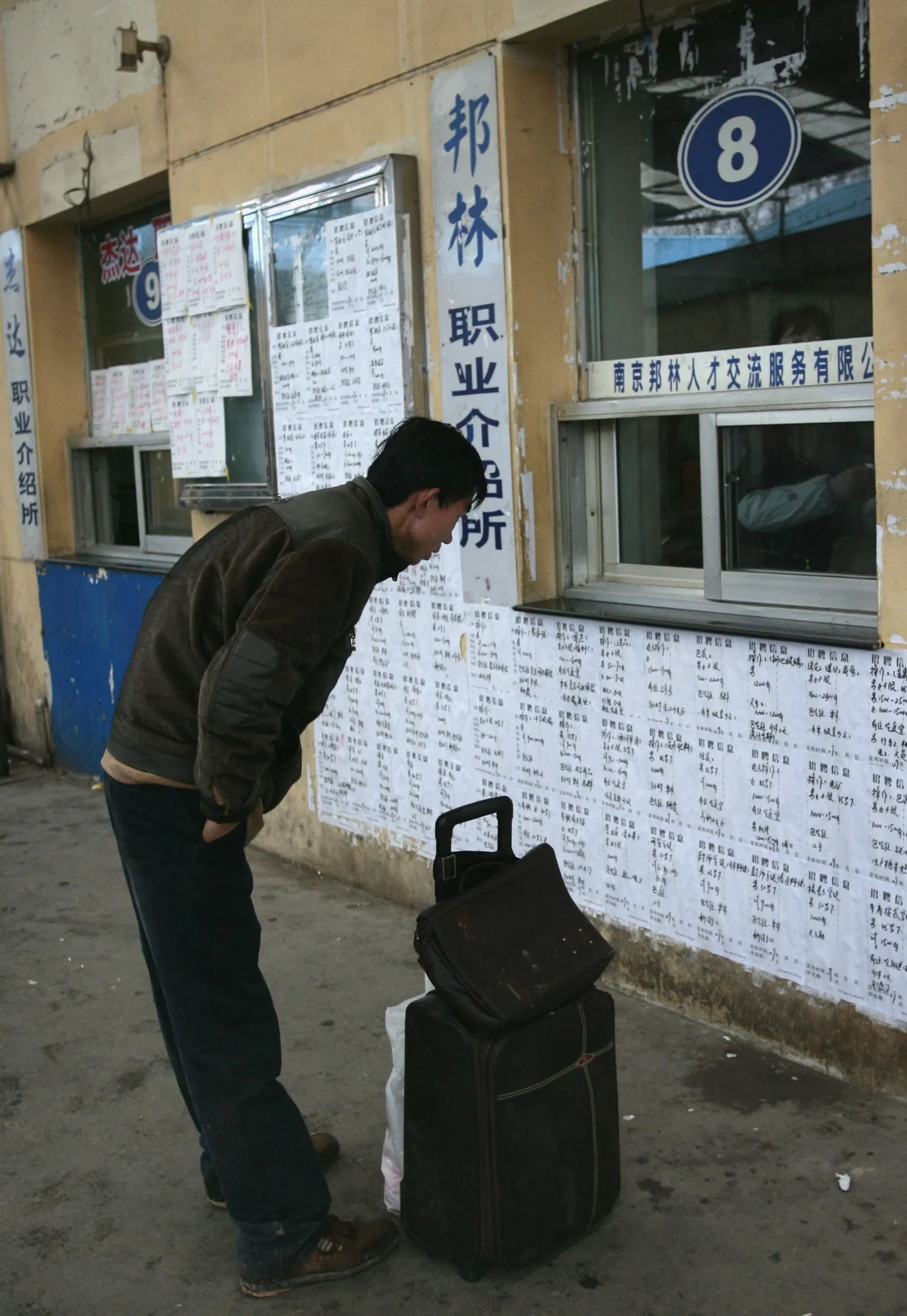 Maalt linna saabunud hiinlane loeb tööpakkumis- ja otsimiskuulutusi.
