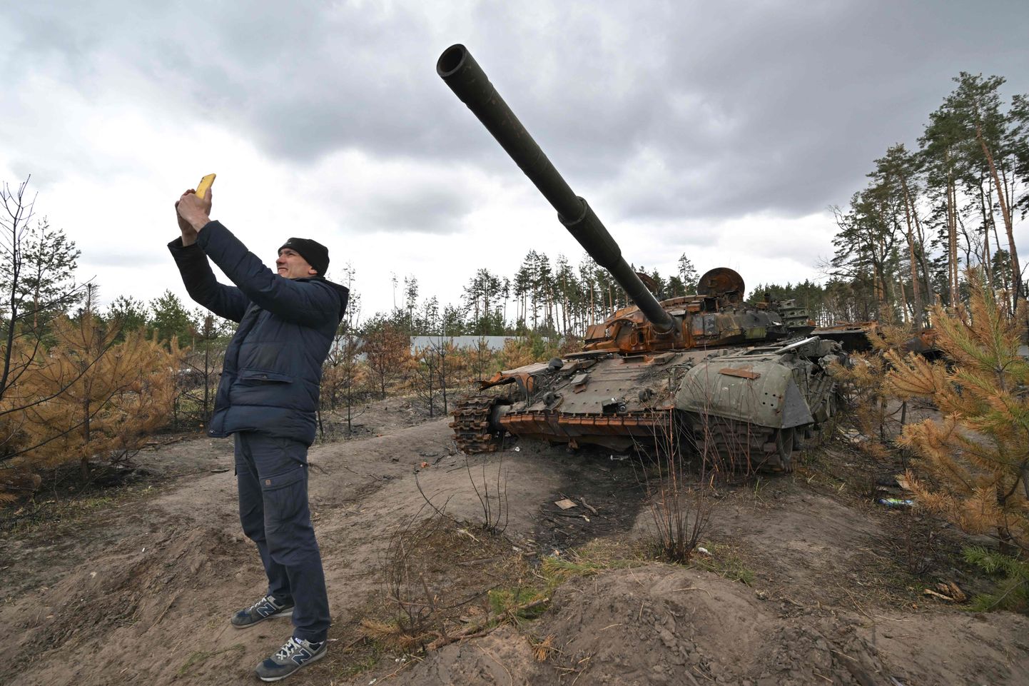 Ukrainas iedzīvotājs pie iznīcināta Krievijas armijas tanka.