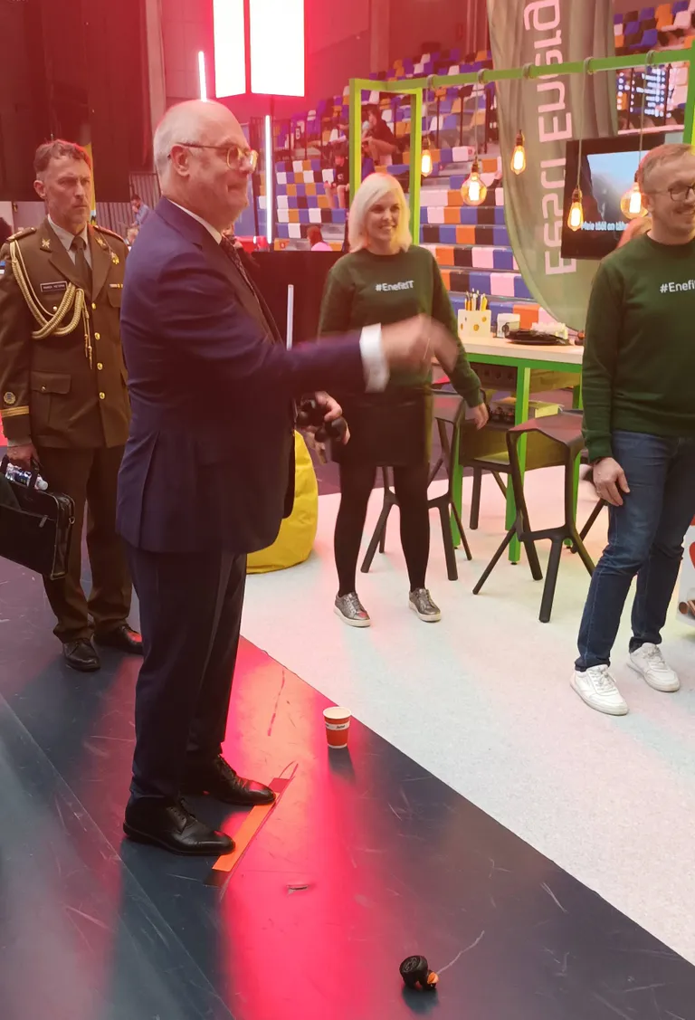 Адьютант президента внимательно смотрит, насколько точно Алар Карис бьет в цель.