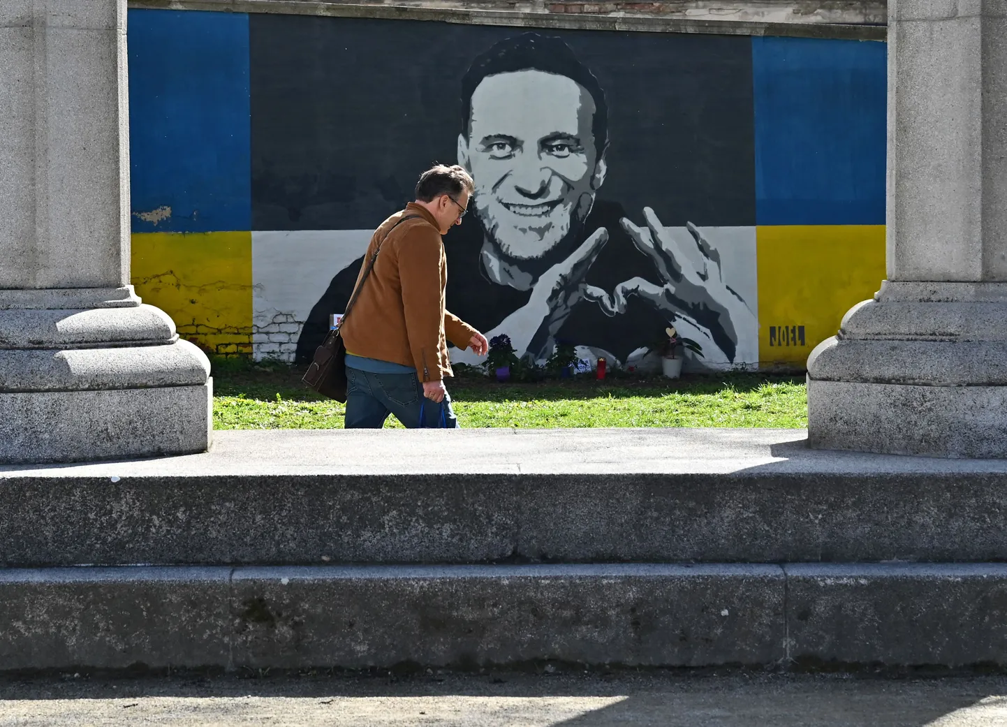 Mees jalutamas mööda Aleksei Navalnõi graffitist Viinis.