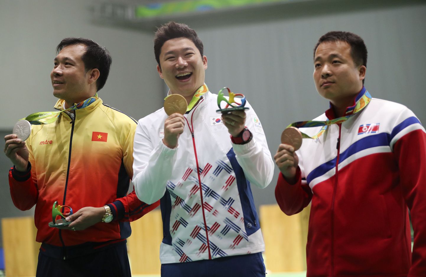 Kullavõitja Jin Jong-oh (keskel). Vasakul hõbemedali pälvinud Hoang Xuan Vinh ja paremal pronksiomanik Kim Song Guk.
