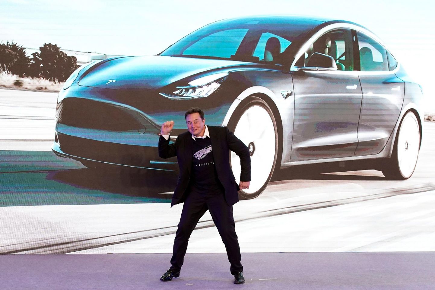 Tesla juht Elon Musk eputab Hiinas tehtud Tesla Model 3 taustal.