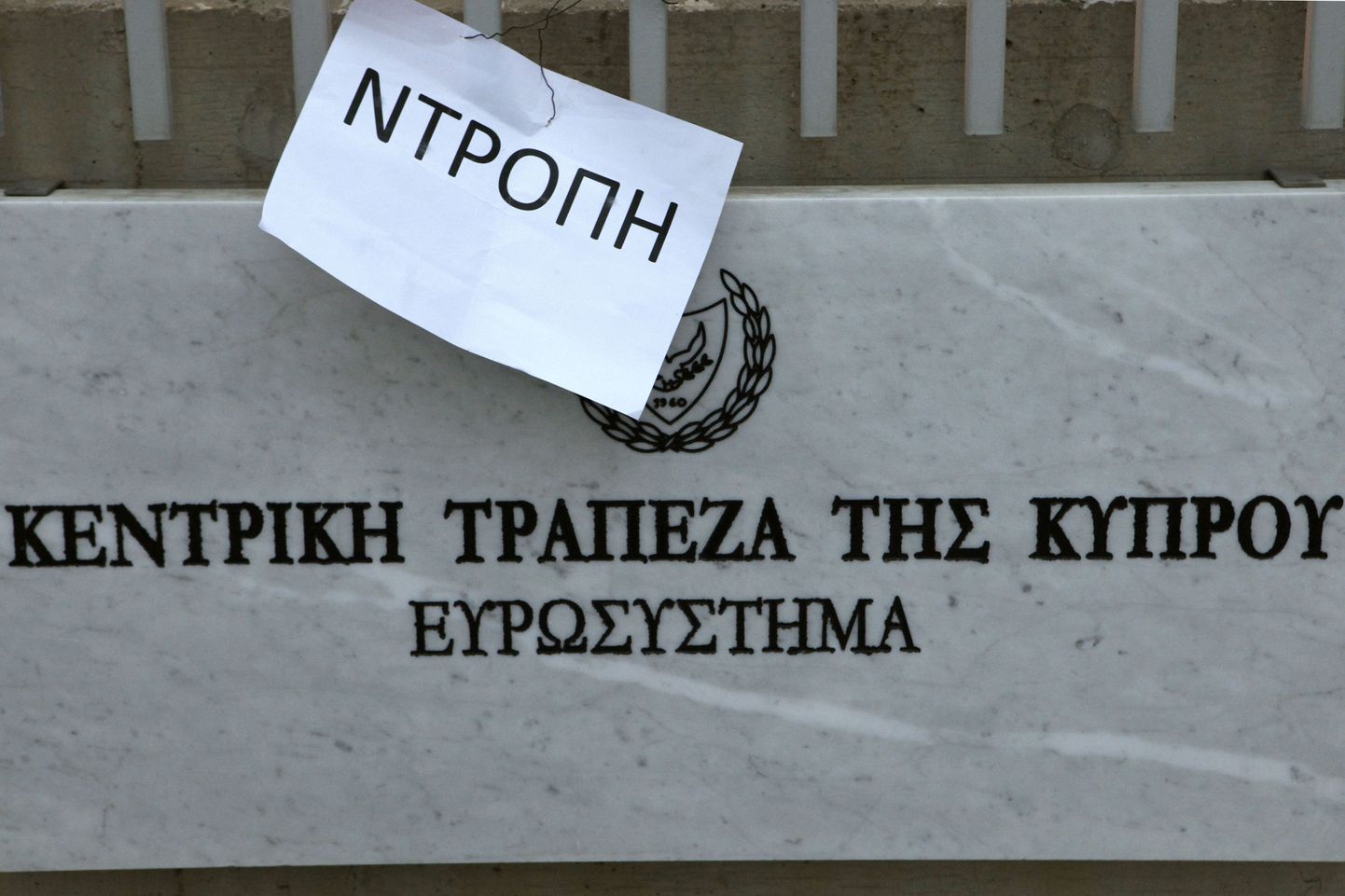 Küprose keskpanga sissekäigu juurde kinnitatud paberileht sõnumiga «häbi».