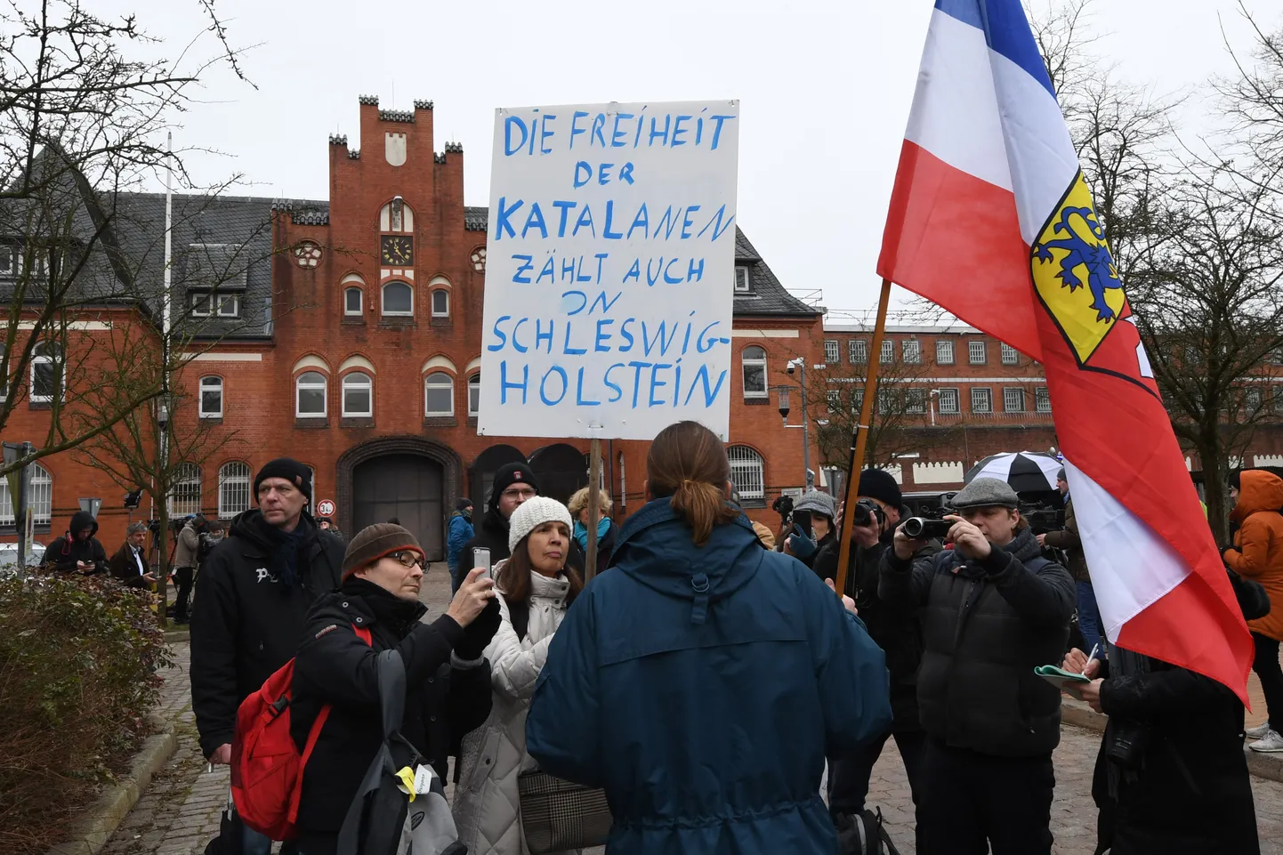 Kataloonia endise presidendi Carles Puigdemonti vahistamise vastu meelt avaldav mees ajakirjanike piiramisrõngas täna Neumünsteri vangla ees. Plakat tema käes teatab: «Katalaanide vabadus loeb ka Schleswig-Holsteinis.»