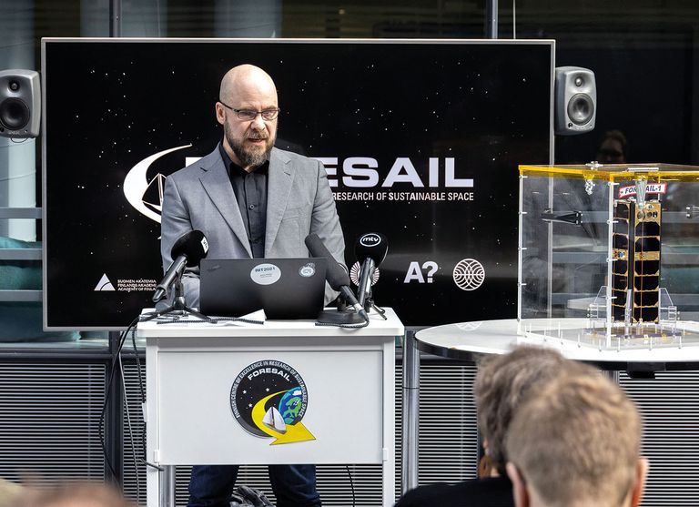 Jaan Praks tänavu aprillis sateliiti Foresail-1 esitleval pressikonverentsil. Mais kosmosesse jõudnud satelliidi lennumudel on näha tema kõrval olevas läbipaistvas karbis.