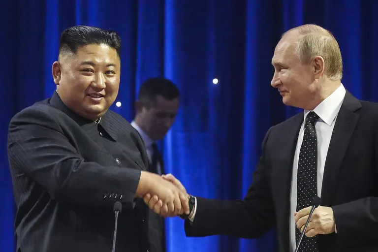 Лидер Северной Кореи Ким Чен Ын, не глядя, жмет руку Владимиру Путину после переговоров в 2019 году.