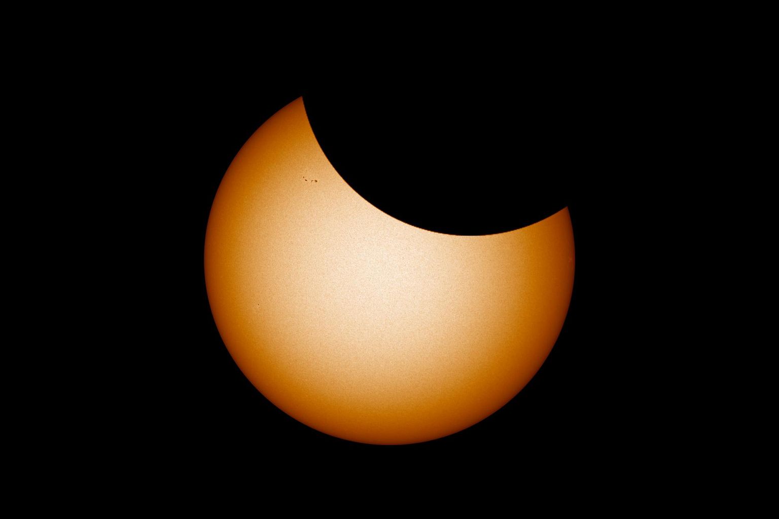 Selline võiks neljapäevane päikesevarjutus tipphetkel välja näha teleskoobis. Foto Päikesest on tehtud 30. mail 2021 ning sellel on näha ka mõned pisikesed päikeseplekid, mis on neljapäevaks liikunud Päikese paremasse serva või sootuks kadunud. Loodetavasti on selleks ajaks tekkinud mõni uus juurde.