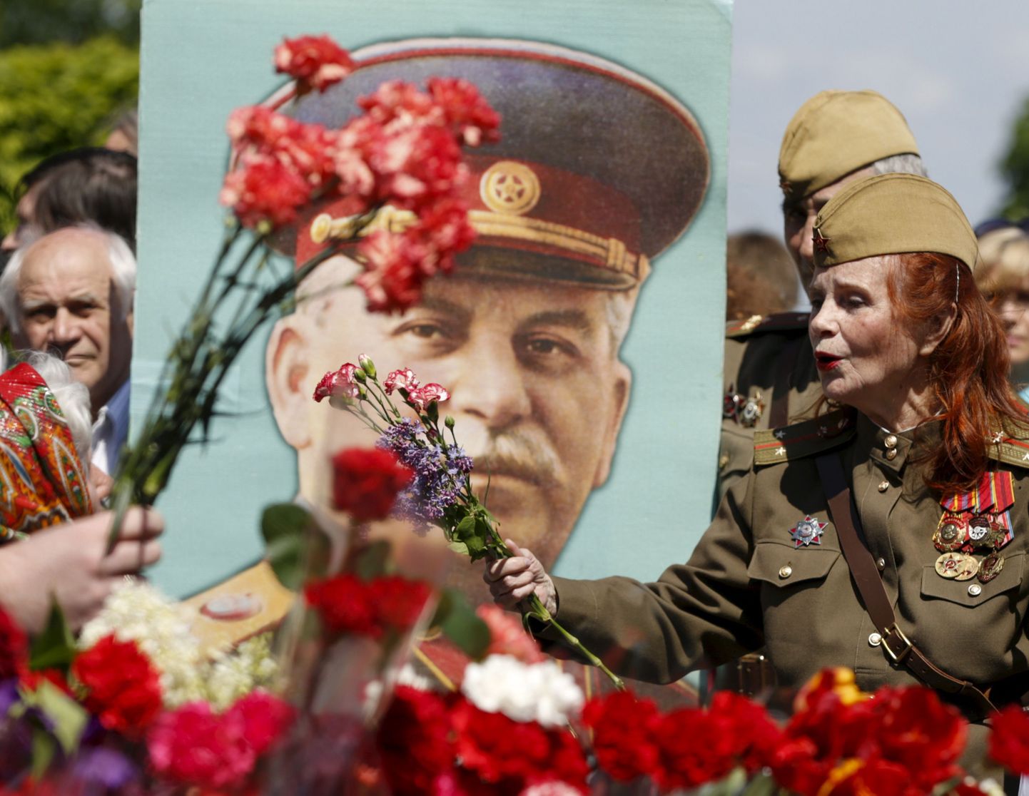 Moskvalased punaste nelkide ja Jossif Stalini pildiga Tundmatu sõduri haua juures lustimas.