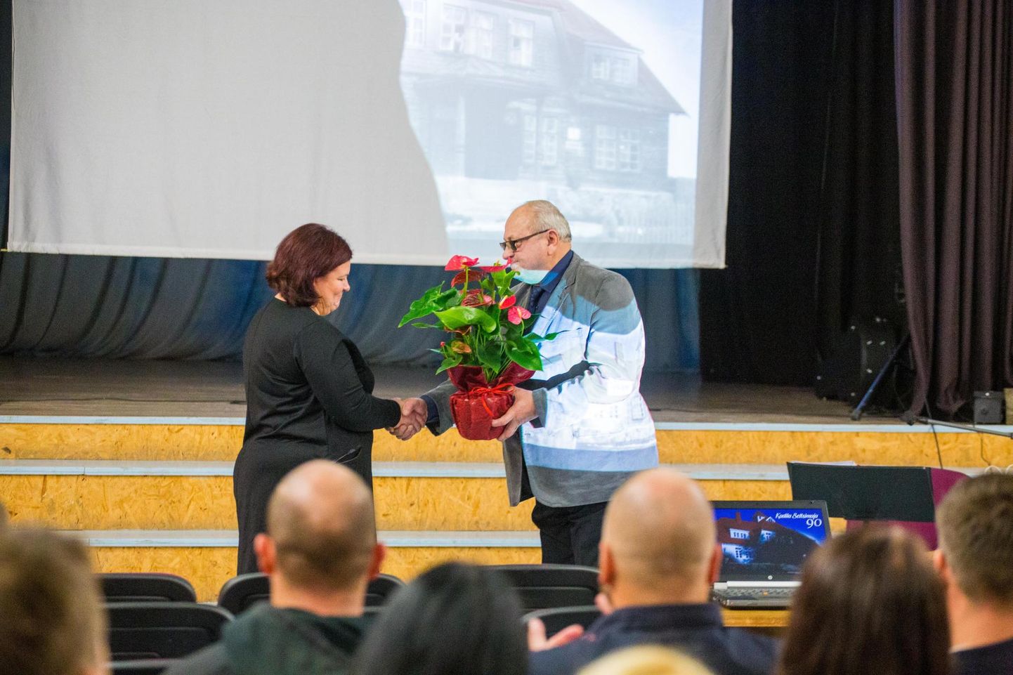 Vinni vallavolikogu liige eksvallavanem Toomas Väinaste annab lilled koos parimate soovidega Kadila seltsimaja perenaisele Kaili Kõrgesaarele.