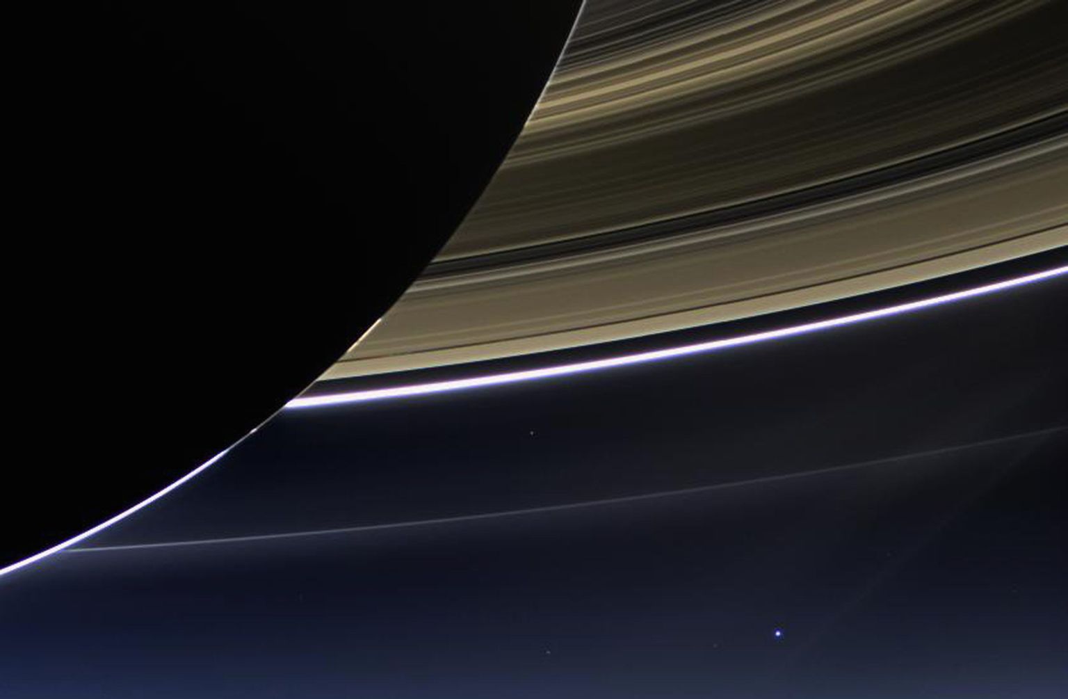 2017. aastal lõpetava Cassini missiooni foto Saturnist, selle ratastest ja kuust ning Maast. Maa paistab pildi keskosast veidi paremal väikese sinise täpina.