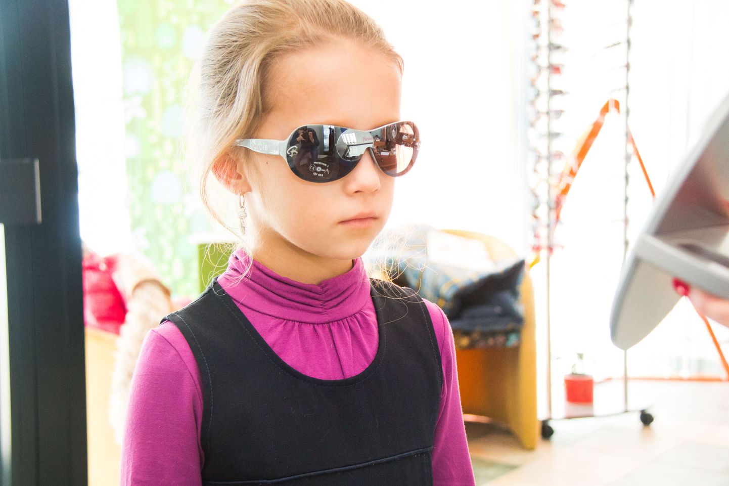 Seitsmeaastane Sofia optikapoes päikeseprille proovimas. Laste puhul tuleks eriti hoolega jälgida, et tegu oleks kvaliteetse polaroidi, mitte vaid tavalise värvilise klaasiga.