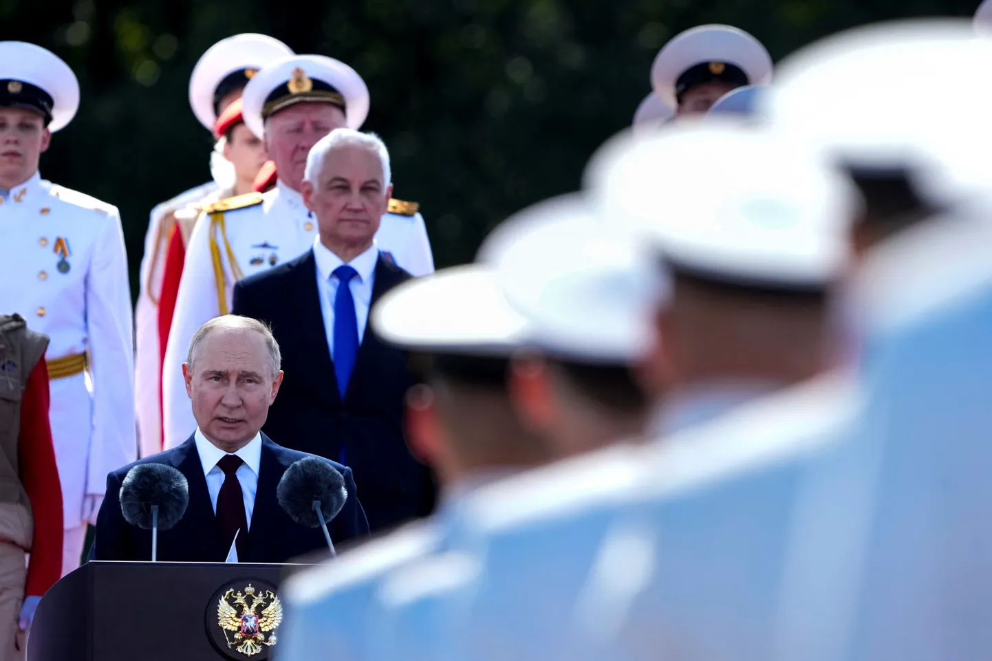 Путин выступает на параде в честь дня Военно-морского флота РФ, Санкт-Петербург, 28 июля 2024 года. За спиной Путина стоит министр обороны РФ Андрей Белоусов, который в мае 2024 года сменил на этом посту Сергея Шойгу.