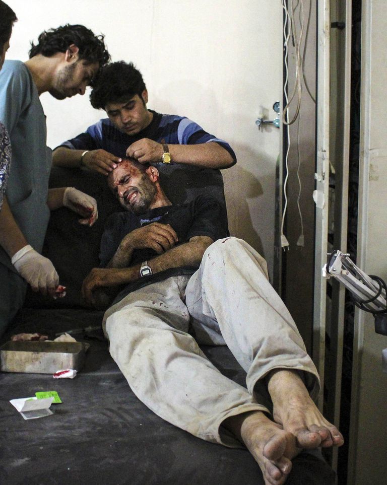 Kaaslased ravivad Damaskuses režiimivägede õhurünnakus viga saanud meest. 