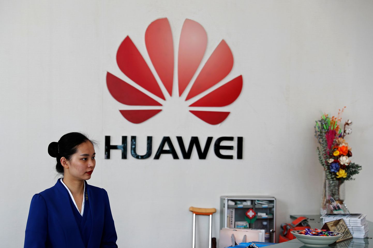 Huawei töötaja ja ettevõtte logo Shenzhenis Hiinas, Guangdongi provintsis.