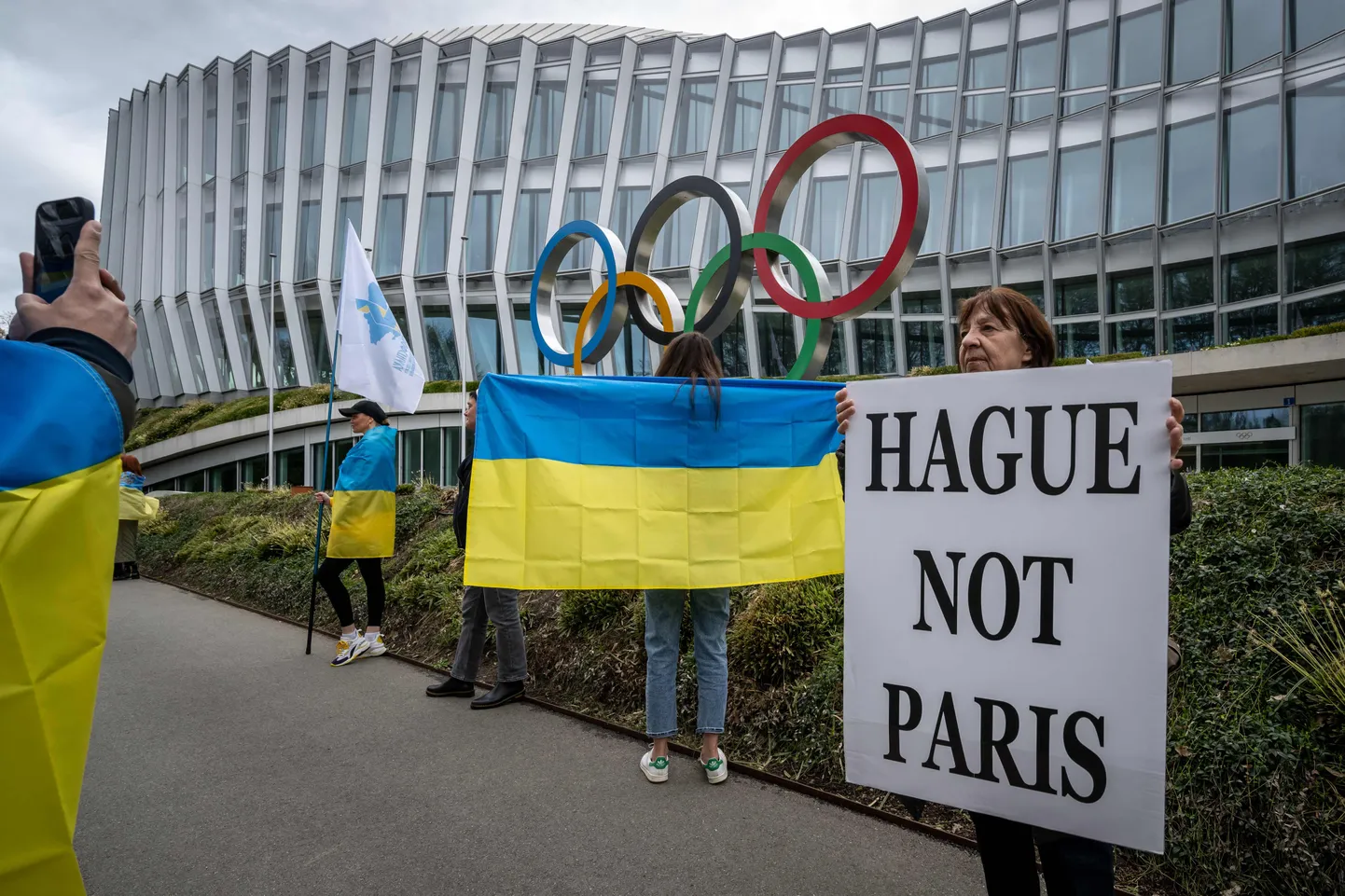 Ukrainlased ja nende toetajad protestimas Lausanne'is Rahvusvahelise Olümpiakomitee peakorteri juures sõnumiga, et venelased peavad minema Haagi tribunali alla, mitte Pariisi olümpiamängudele.