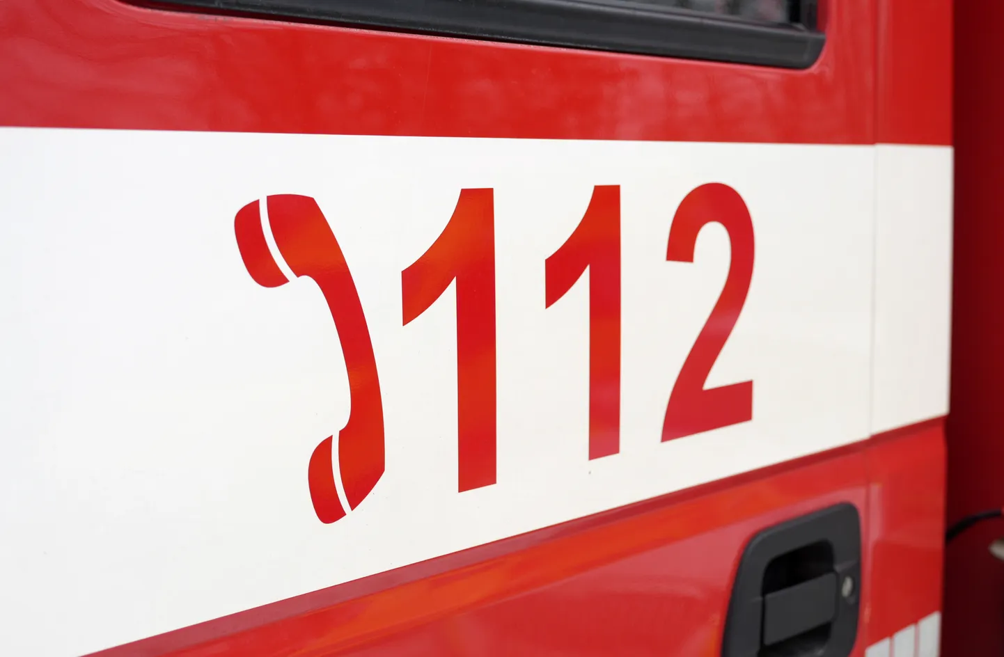 Vienotais ārkārtas palīdzības izsaukumu numurs "112" uz Valsts ugunsdzēsības un glābšanas dienesta automašīnas durvīm.
