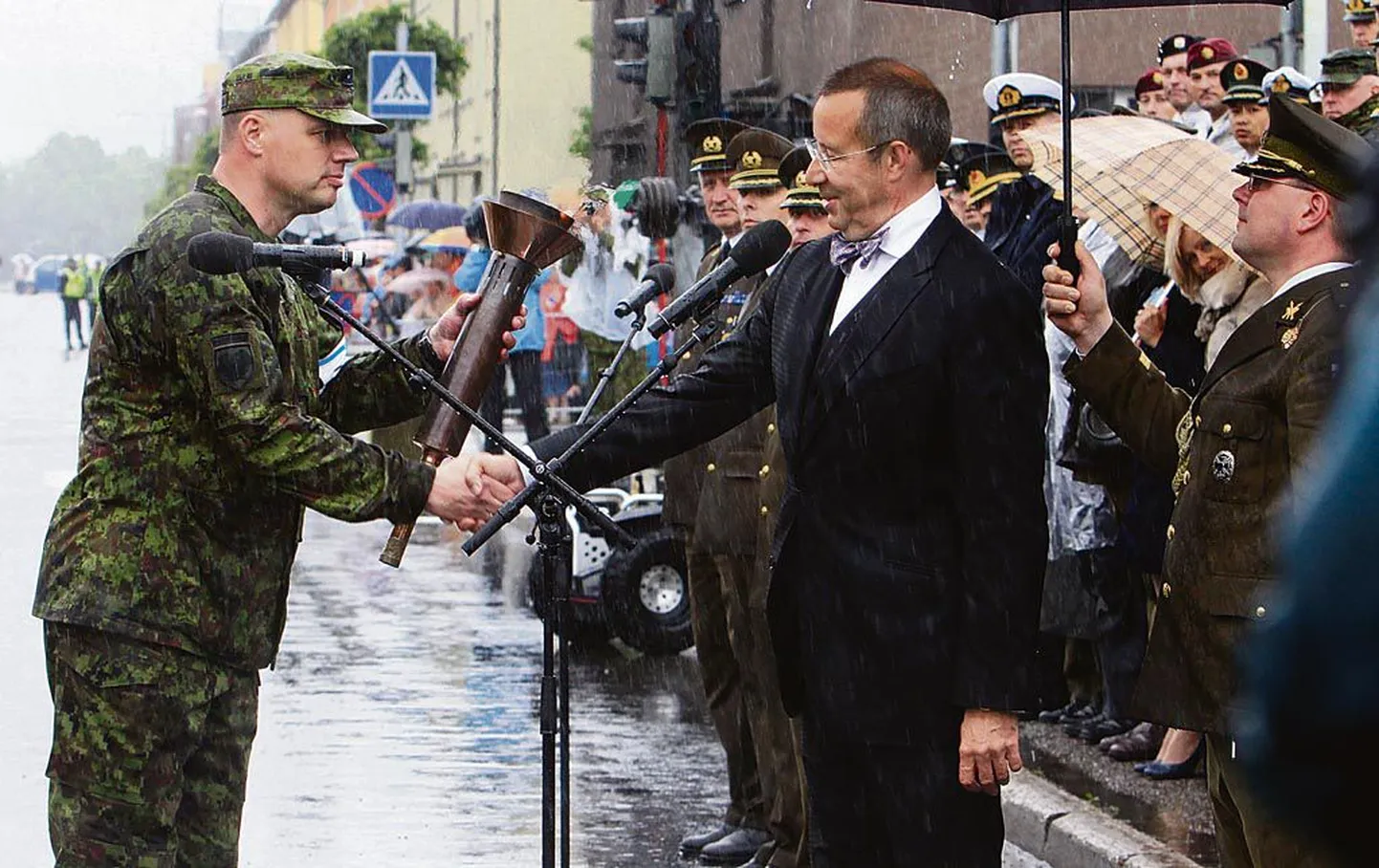 Eesti Vabariigi president Toomas Hendrik Ilves saab major Mehis Bornilt, Kaitseliidu Pärnumaa maleva pealikult, Toris Eesti sõjameeste mälestuskirikus süüdatud võidutule.