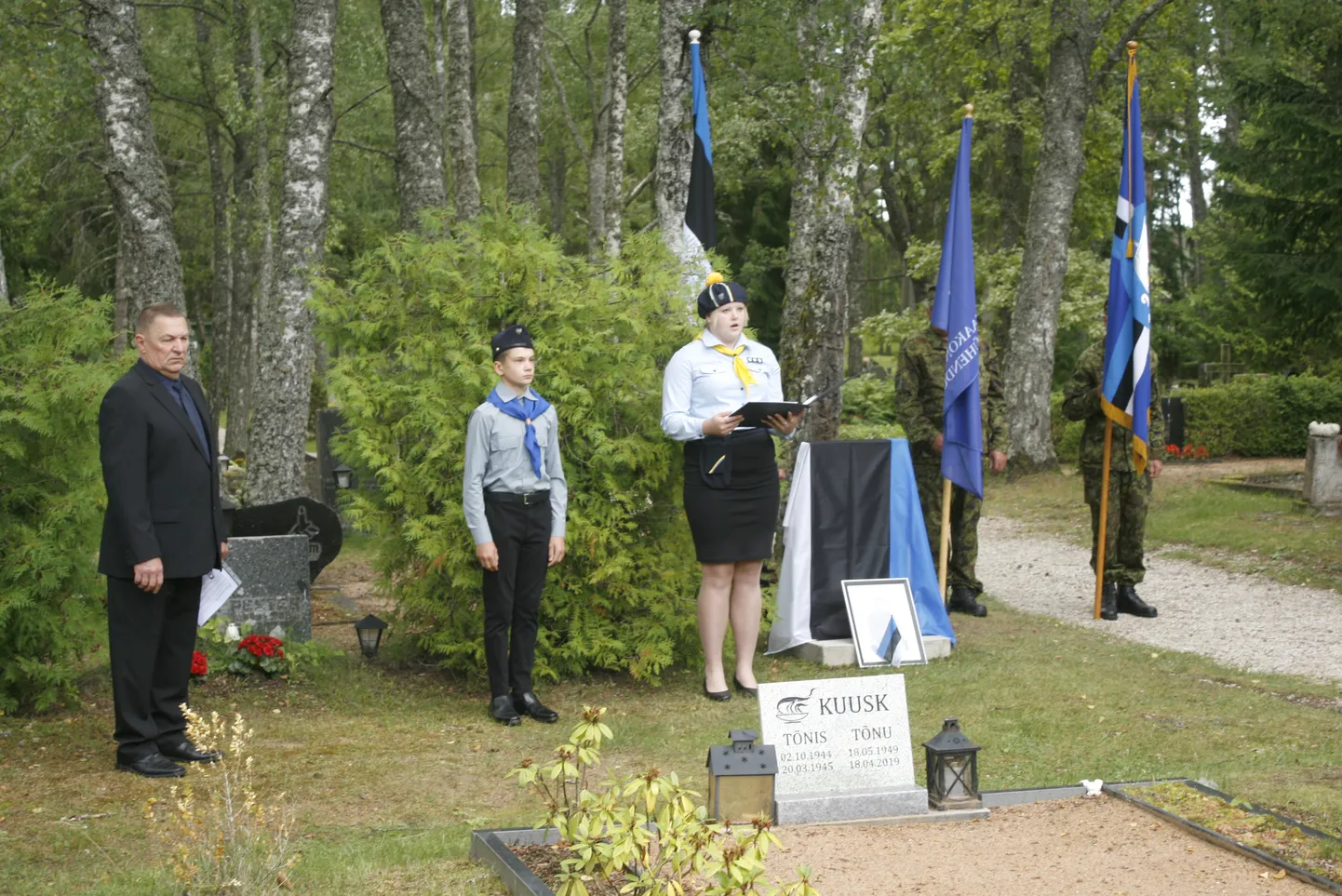 KENOTAAFI AVAMINE: Saaremaa metsavendluse uurija Mati Vendel ja kohalik noorkotkas Risto Nurk kuulavad kodutütarde Leisi rühma juhi Eliise Vohu etteloetavat metsavend Redese Toomsoni luuletust.
