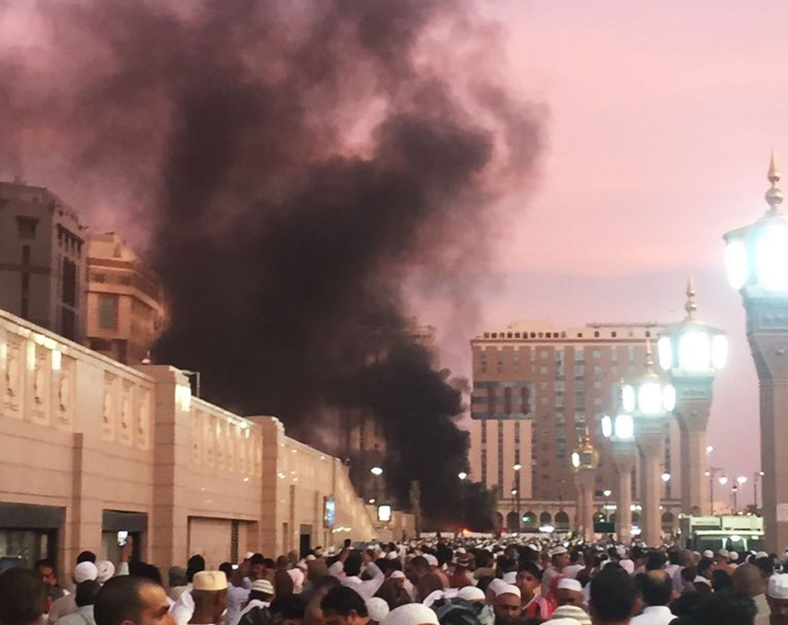 Rahvas Medinas  plahvatusest tõusnud suitsu jälgimas. Tegu on moslemite püha linnaga.